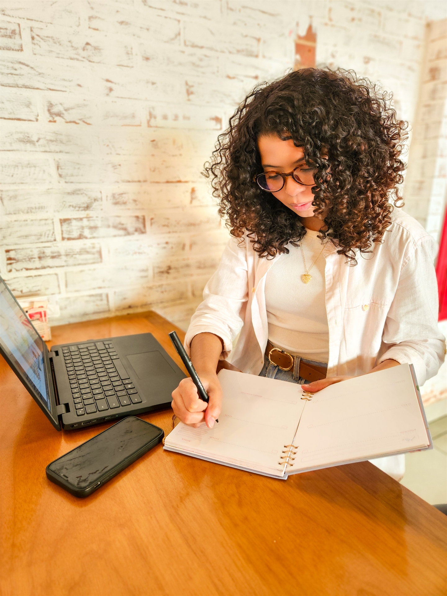 Beatriz Kamizato trabalhando em seu caderno ao lado do computador